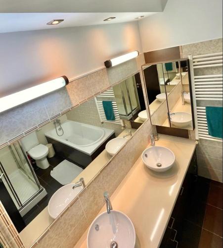 a bathroom with two sinks and a tub and a mirror at El Soleo Luxury Villa in Limassol