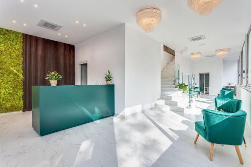 a lobby with green chairs and a reception desk at Hotel Anversa Rimini in Rimini