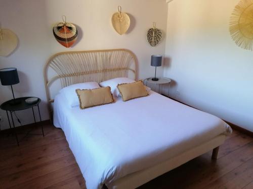 una camera da letto con un letto bianco con due cuscini sopra di Maison sur le Bassin d'Arcachon a La Teste-de-Buch