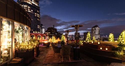 a patio with christmas trees and lights in a city at Mariah Carey’s Ultimate Holiday Experience in New York City in New York