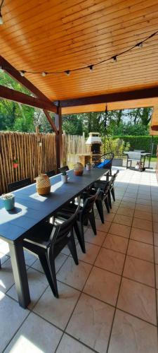 une table bleue et des bancs sur un patio dans l'établissement Maison sur le Bassin d'Arcachon, à La Teste-de-Buch