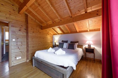 1 dormitorio con 1 cama grande en una cabaña de madera en ST JORIOZ- Cosy Chalet vue lac et montagnes - LLA Selections by Location Lac Annecy, en Saint-Jorioz