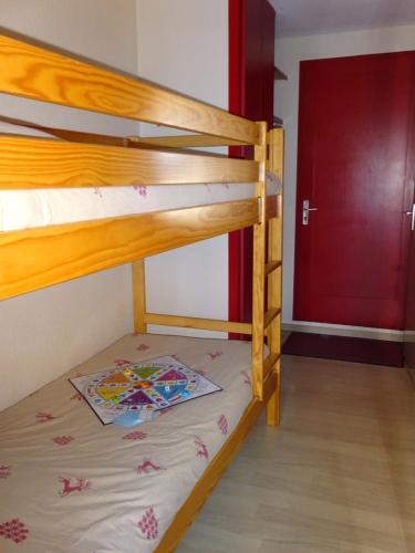 a bunk bed in a room with a red door at BIENVENUE AU LIORAN in Le Lioran