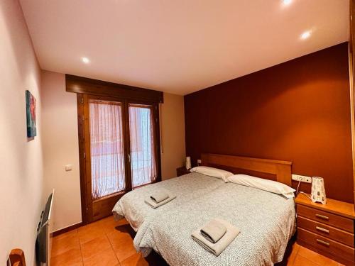 een slaapkamer met een bed met twee handdoeken erop bij Apartamento Carlos Bielsa in Bielsa