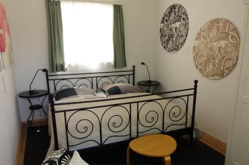 a bedroom with a black bed with pillows and a window at Campus Apartment Ernst in Dresden