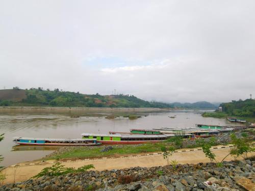 a group of boats on a river at Manilath guesthouse in Ban Houayxay