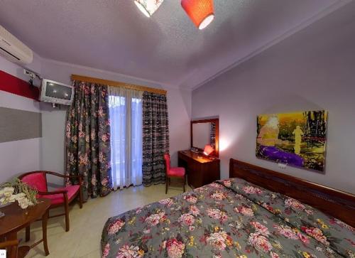 a bedroom with a bed and a table and chairs at Dryades Hotel in Naousa Imathias