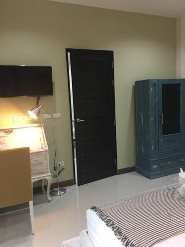 a bedroom with a black door and a bed and a desk at Snapper House in Khao Lak