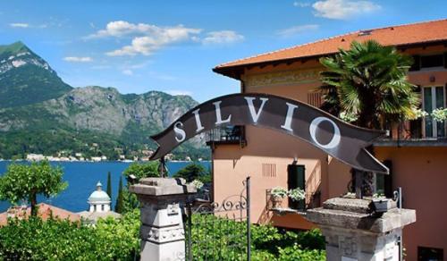 a sign in front of a building next to a body of water at Albergo Silvio in Bellagio