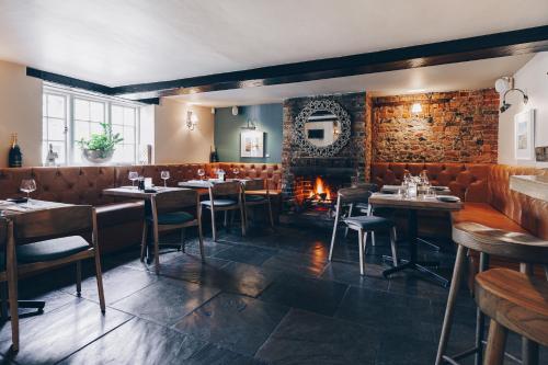 a restaurant with tables and chairs and a fireplace at The Crab & Lobster in Chichester