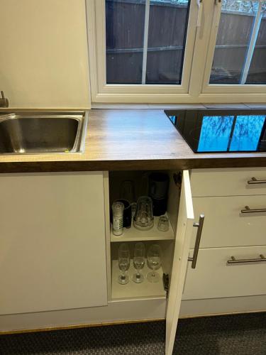 a kitchen with a sink and a counter with cups at Tranquil Gardens in Loughborough