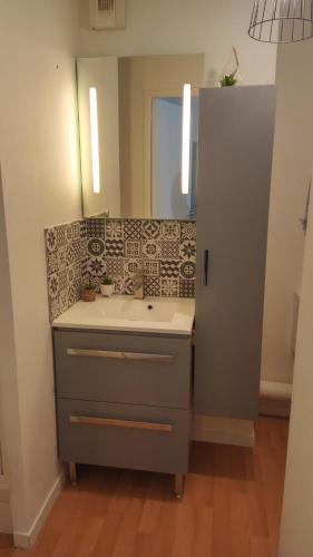 a bathroom with a sink and a mirror at Ty kalon in Carantec