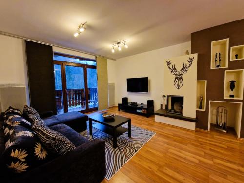 a living room with a couch and a table and a tv at Dream Apartments No.202 - Right in the heart of Tále in Tale