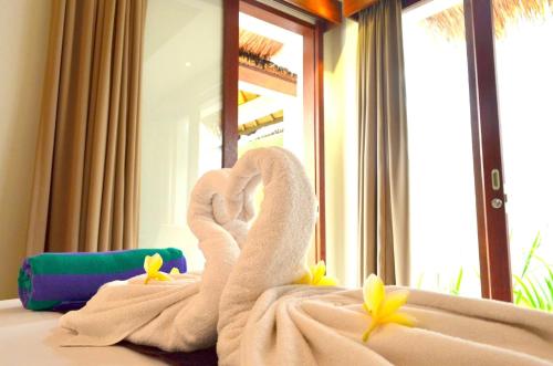 a towel swan on a bed in front of a mirror at Jas Boutique Villas in Seminyak