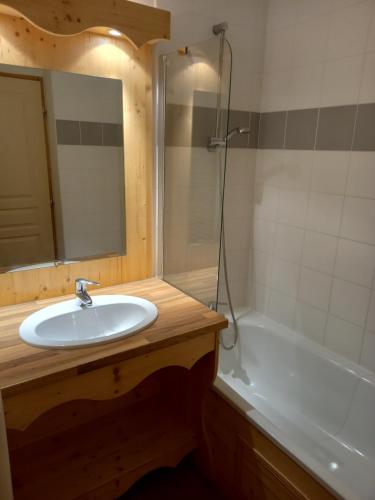 un bagno con un lavandino, una vasca e uno specchio di Appartement Orelle, domaine Les 3 vallées / Val Thorens a Orelle