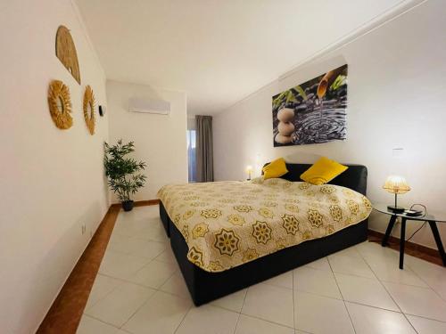 sypialnia z dużym łóżkiem z żółtymi poduszkami w obiekcie Apartamento Varandas do Mar w Albufeirze