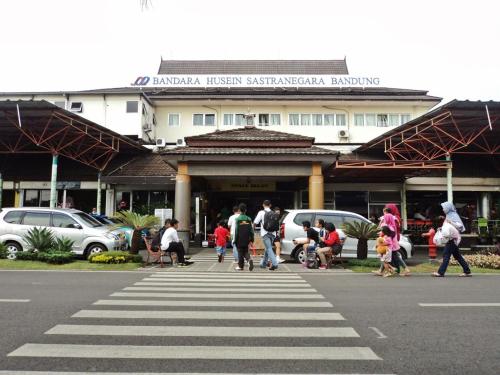 a group of people crossing a street in front of a building at Yokotel Hotel in Bandung