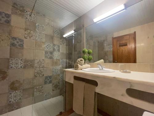 W łazience znajduje się umywalka i lustro. w obiekcie Apartamento Varandas do Mar w Albufeirze