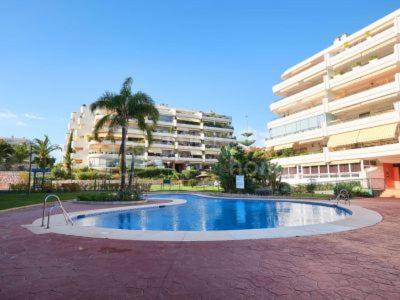 una gran piscina frente a un edificio en Ático 2 Dormitorios en campo de Golf Guadalmina, Marbella, en Marbella