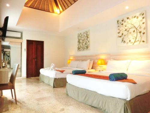 a bedroom with two beds and a table and chairs at Jas Boutique Villas in Seminyak