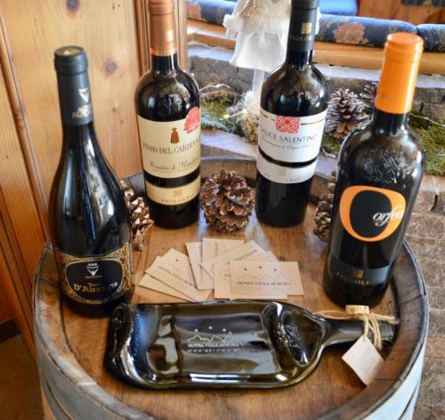 three bottles of wine sitting on top of a barrel at Hotel Villa Aurora in San Martino di Castrozza