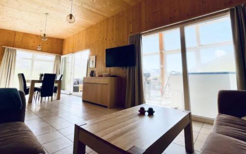 a living room with a table and a large window at Hidden Cottages in Kvíabekkur