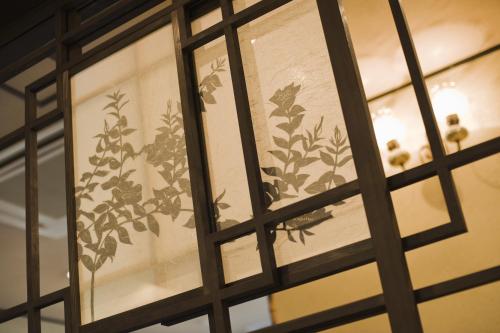 a glass door with a window with flowers on it at Taikyourou in Miyazu