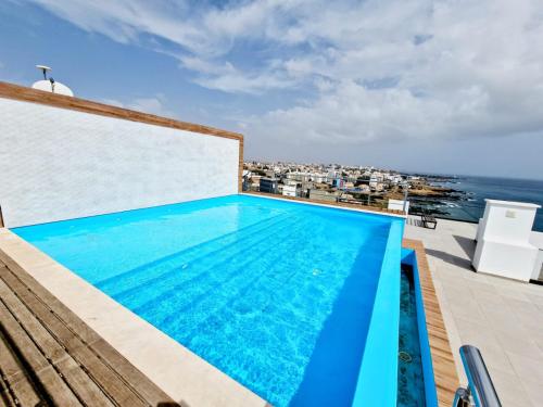 uma piscina no telhado de um edifício com o oceano em Praia Modern Apartment vista Mar em Praia