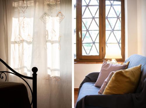 a living room with a blue couch and a window at Casetta di Butia, Glicine Apartment in Borgo a Mozzano