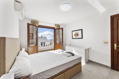 een slaapkamer met een groot wit bed en een raam bij Villa Reymar in Tías