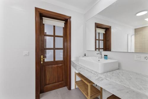 een badkamer met een witte wastafel en een spiegel bij Villa Reymar in Tías