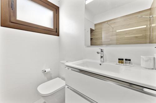 a bathroom with a toilet and a sink and a mirror at Villa Reymar in Tías