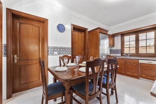 a kitchen with a wooden table and chairs at Villa Reymar in Tías