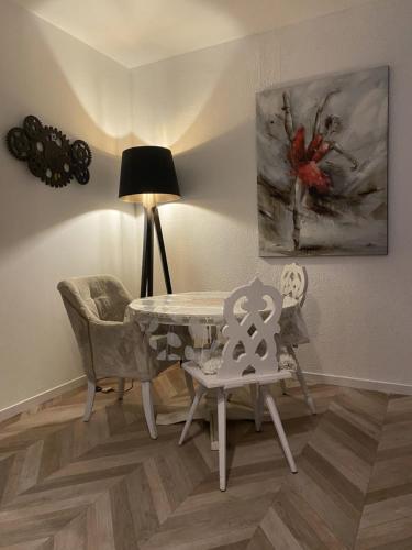 une salle à manger avec une table et des chaises et un tableau dans l'établissement SUZANNE STRASBOURG, à Strasbourg