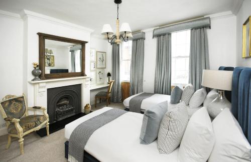 a hotel room with two beds and a fireplace at Dolls House - Luxury Townhouse *sleeps 10* in Henley on Thames
