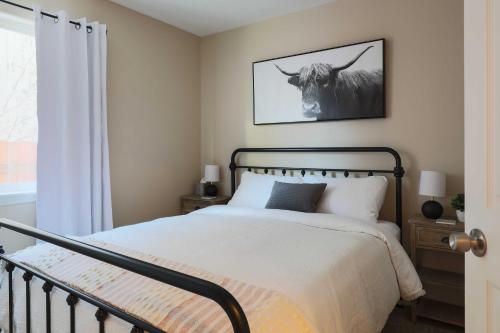 a bedroom with a bed with a bull picture on the wall at Charming Anchorage Townhouse with Fire Pit! in Anchorage