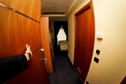 a person opening a door to a room with a hallway at Best Western Hotel Class Lamezia in Lamezia Terme