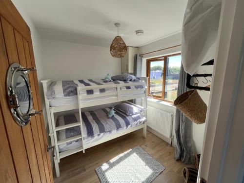 a small bedroom with a bunk bed and a window at Oak Valley Lodges in Pett