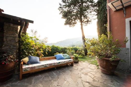 a bench with pillows sitting on a patio at Casetta di Butia, Glicine Apartment in Borgo a Mozzano
