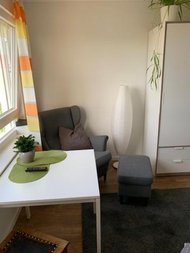 een woonkamer met een tafel en een stoel bij Studio mit Weitblick 