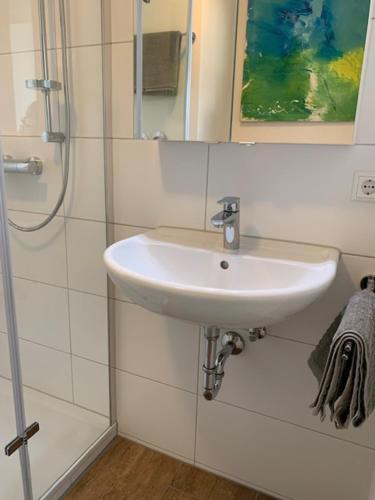 a white bathroom with a sink and a shower at Studio mit Weitblick 