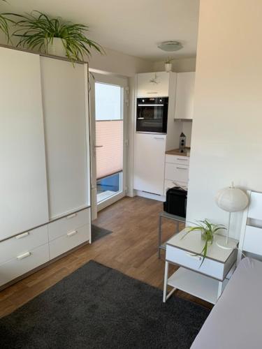 a kitchen with white cabinets and a table with plants on it at Studio mit Weitblick 