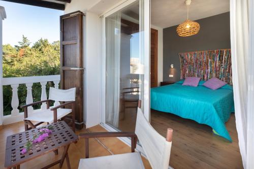 a bedroom with a green bed and a balcony at Casa en Ibiza con vistas increíbles en Es Figueral in Es Figueral Beach
