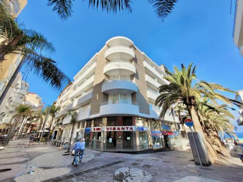 a man riding a bike in front of a building at La Hoya 29 Apartments in Puerto de la Cruz