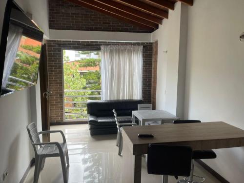 a living room with a table and chairs and a window at Medellin cerca a plaza mayor in Medellín