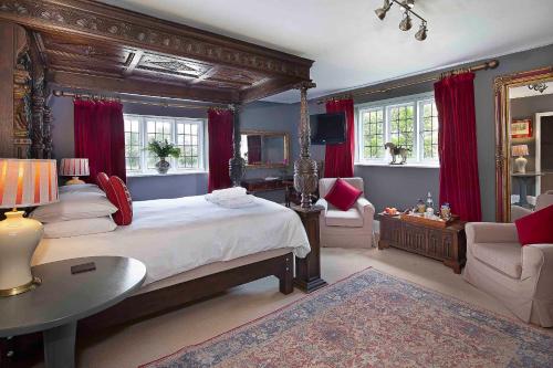 a bedroom with a large bed with red curtains at Hill Farm in Oxford