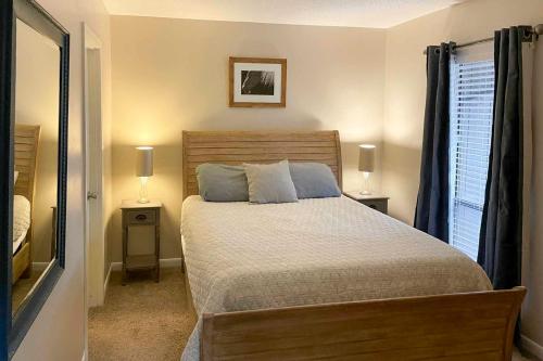 una camera da letto con un letto con due lampade e una finestra di Quiet Pinehurst Condo with Patio on Golf Course! a Pinehurst