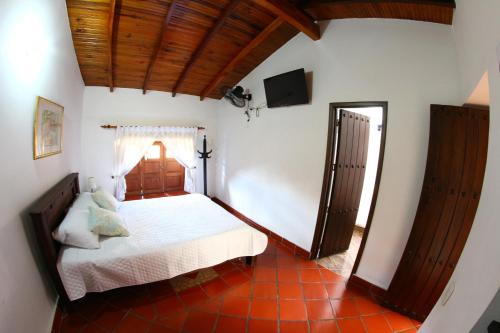 a bedroom with a bed and a television in a room at Real Dream Hostel in San Gil