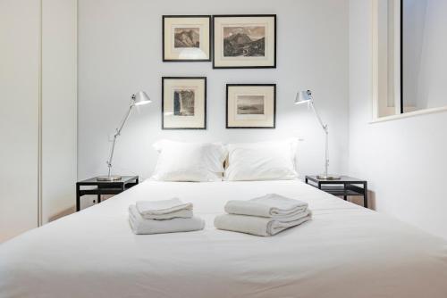 - une chambre avec un lit blanc et 3 serviettes dans l'établissement Castelo Design Aparment W/ Balcony & Super View by LovelyStay, à Lisbonne
