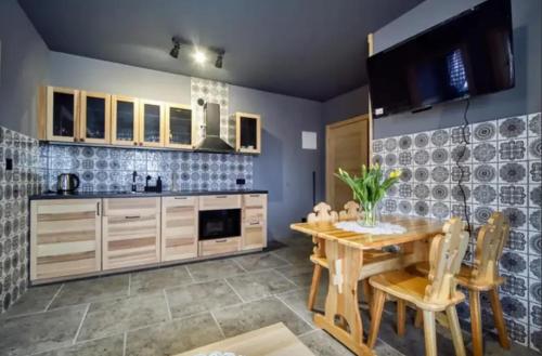kuchnia z drewnianym stołem, stołem i krzesłami w obiekcie Apartamenty Koniaków Residence w mieście Koniaków